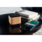 Bocina Bluetooth personalizada con cargador inalámbrico y acabado en bambú para regalos corporativos y promocionales tecnológicos.