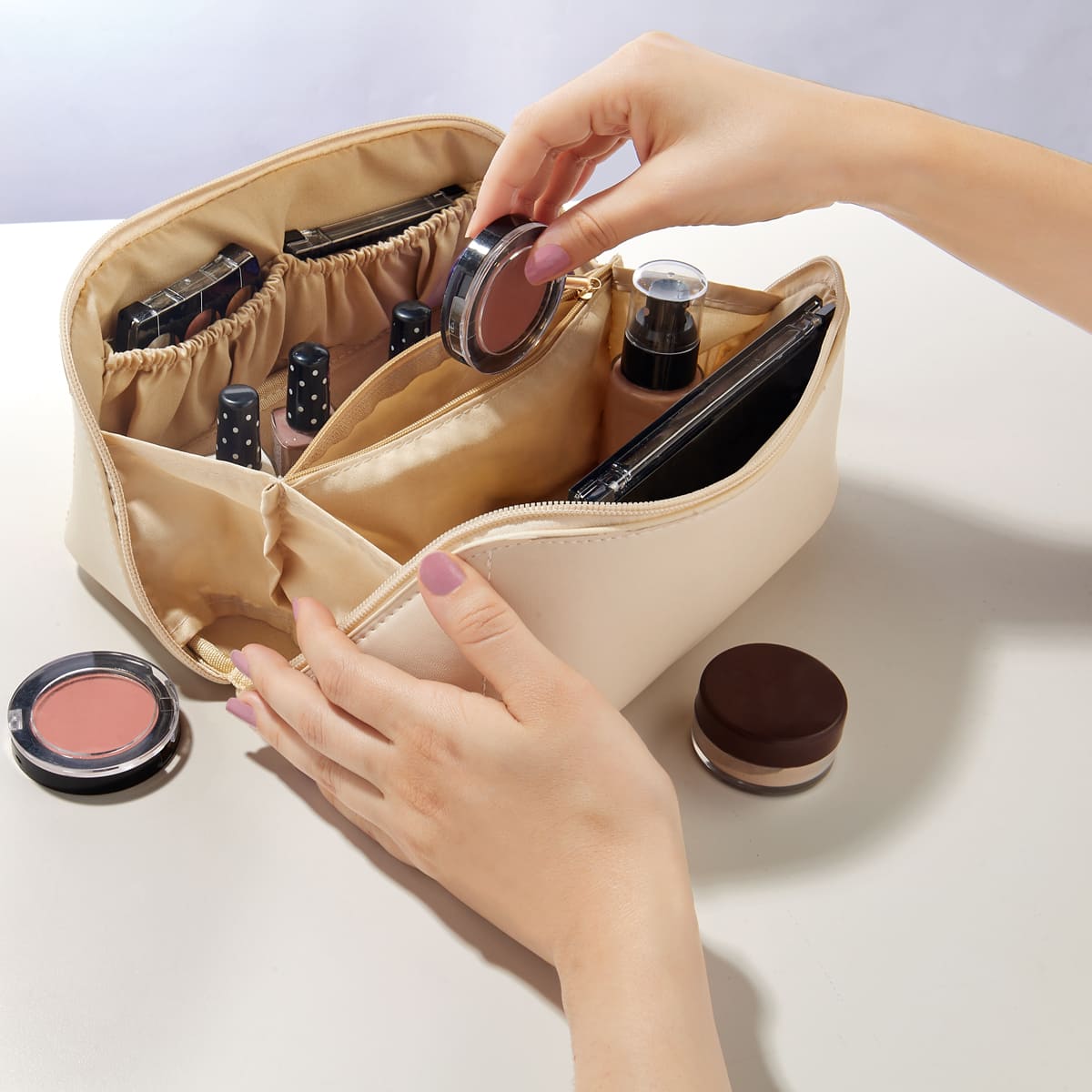 Cosmetiquera de curpiel expandible con tres elásticos organizadores, bolsillo central con cierre y asa personalizada.